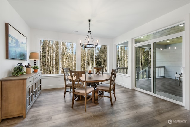 dining space with dark hardwood / wood-style flooring and a chandelier