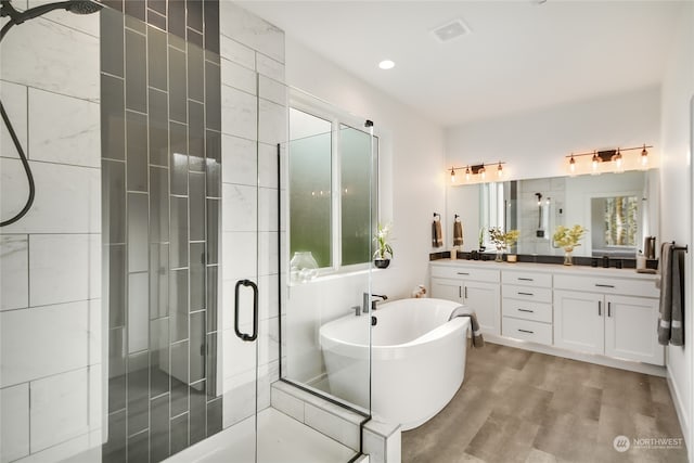 bathroom with plus walk in shower, wood-type flooring, vanity, and plenty of natural light