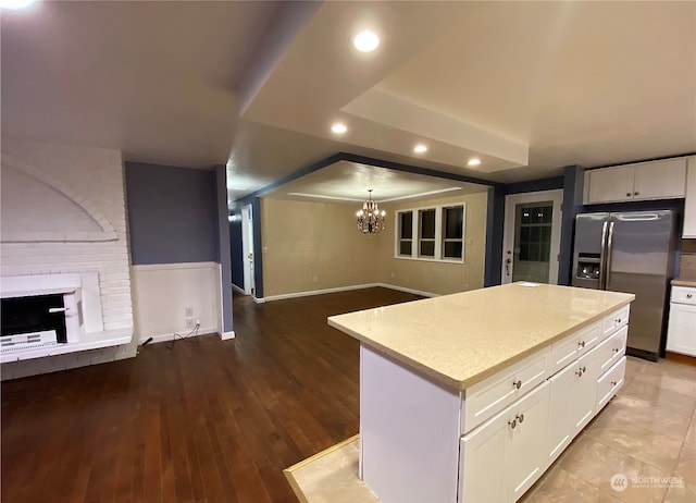 kitchen featuring light wood-type flooring, a center island, a chandelier, and white cabinets