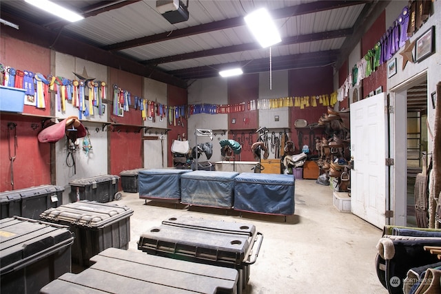 miscellaneous room with beam ceiling and concrete floors