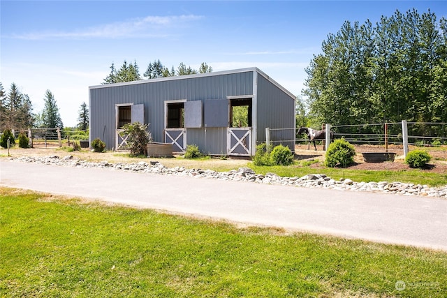 view of front of house with a front yard and an outdoor structure