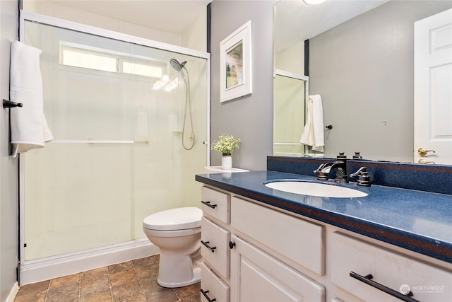 bathroom with a shower with door, tile flooring, toilet, and oversized vanity