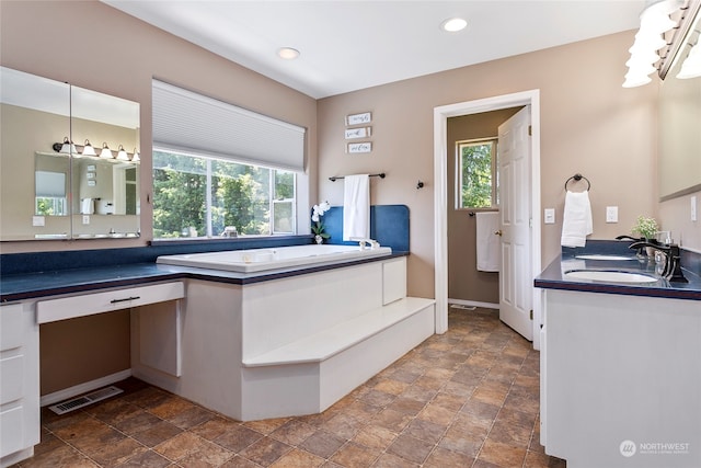 bathroom with tile flooring, a bath, and vanity