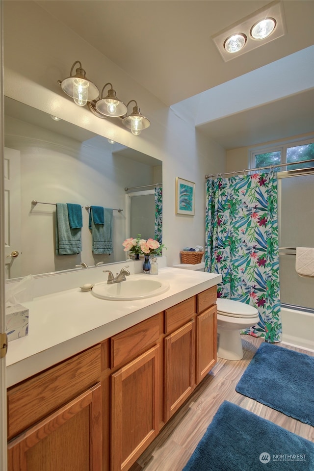 full bathroom with shower / tub combo, vanity, hardwood / wood-style floors, and toilet