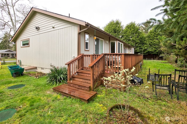 back of house with a deck and a lawn