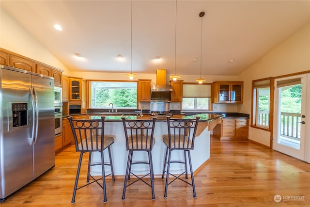 kitchen with stainless steel appliances, a center island, a kitchen bar, and decorative light fixtures