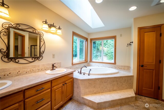 bathroom featuring tiled tub, dual bowl vanity, tile flooring, and a skylight