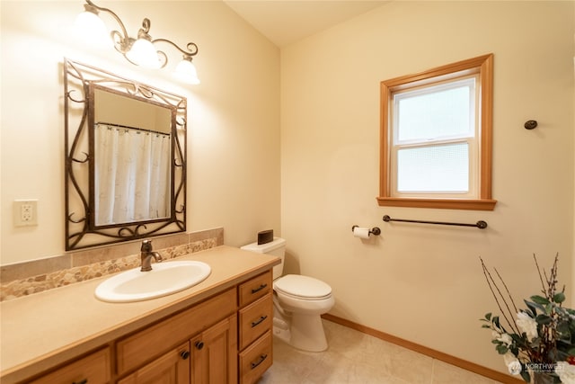 bathroom with toilet, vanity, and tile flooring