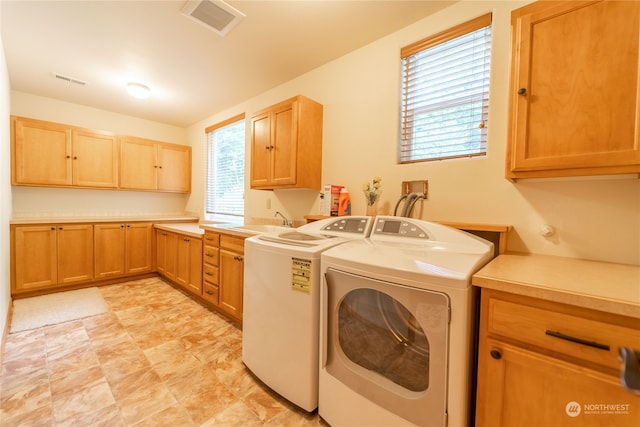 clothes washing area featuring sink, cabinets, washer and dryer, and light tile flooring