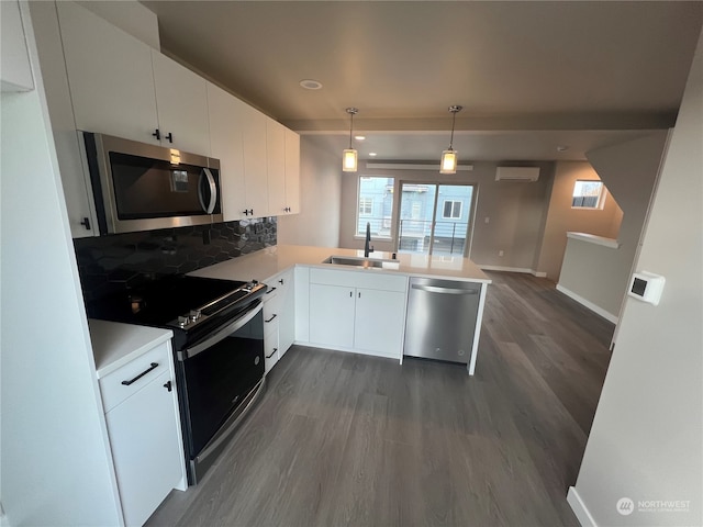 kitchen featuring white cabinets, appliances with stainless steel finishes, kitchen peninsula, and sink