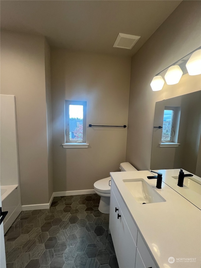 bathroom with a bathing tub, vanity, and toilet