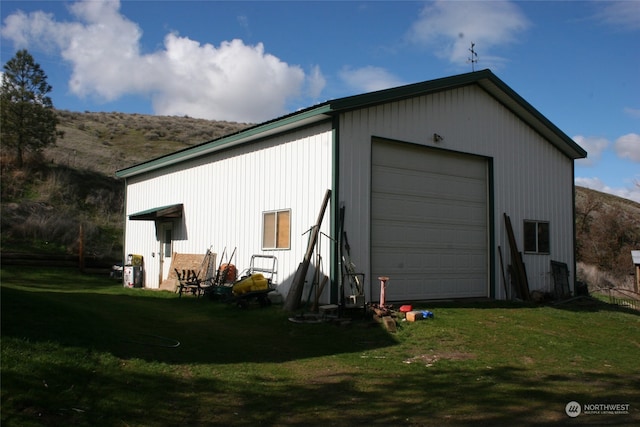 view of outdoor structure featuring a garage and a yard