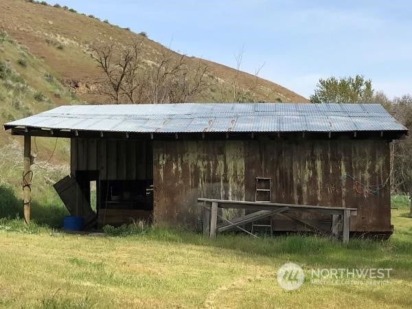 view of outdoor structure with a yard and a mountain view