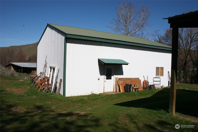 view of outbuilding featuring a lawn