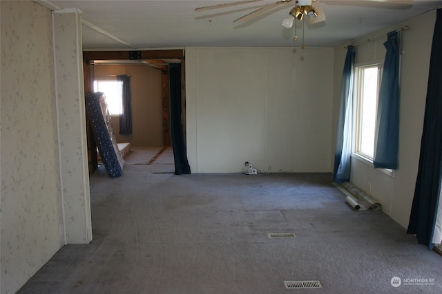 carpeted empty room featuring ceiling fan and plenty of natural light