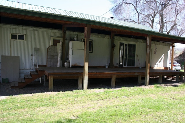 back of house featuring a deck and a lawn