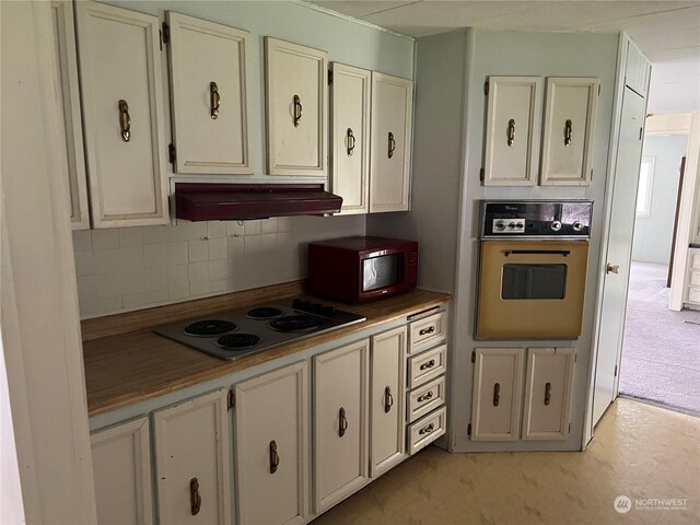 kitchen with white cabinetry, tasteful backsplash, ventilation hood, electric stovetop, and wall oven