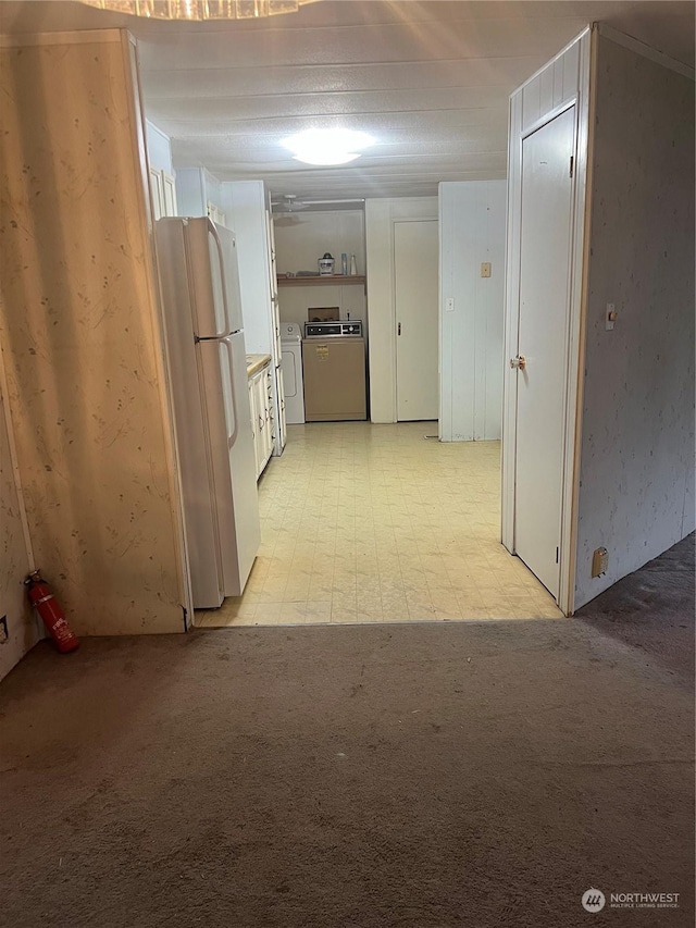 hallway featuring washer and clothes dryer and light colored carpet