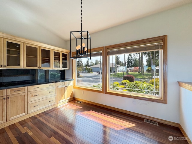 interior space featuring decorative light fixtures, lofted ceiling, hardwood / wood-style flooring, and an inviting chandelier