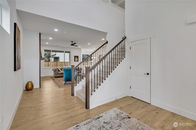 stairway with hardwood / wood-style flooring and ceiling fan