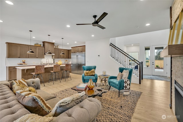 living room with ceiling fan, sink, and light hardwood / wood-style flooring