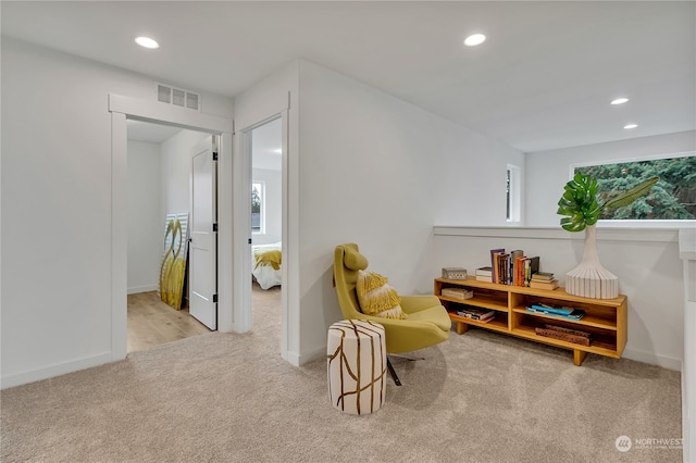 sitting room featuring light colored carpet