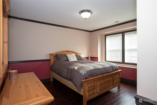 bedroom with dark hardwood / wood-style floors and ornamental molding