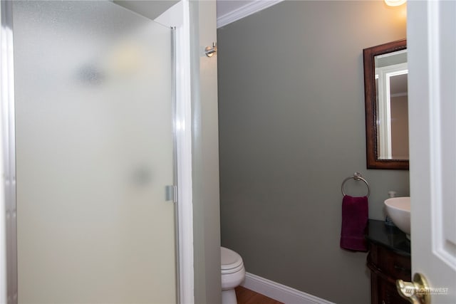 bathroom with vanity, crown molding, hardwood / wood-style floors, and toilet