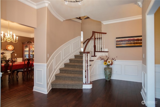 stairway featuring a notable chandelier, crown molding, and dark wood-type flooring