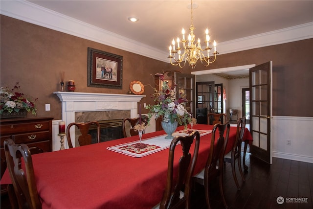 dining room featuring a chandelier, dark hardwood / wood-style floors, a premium fireplace, and crown molding