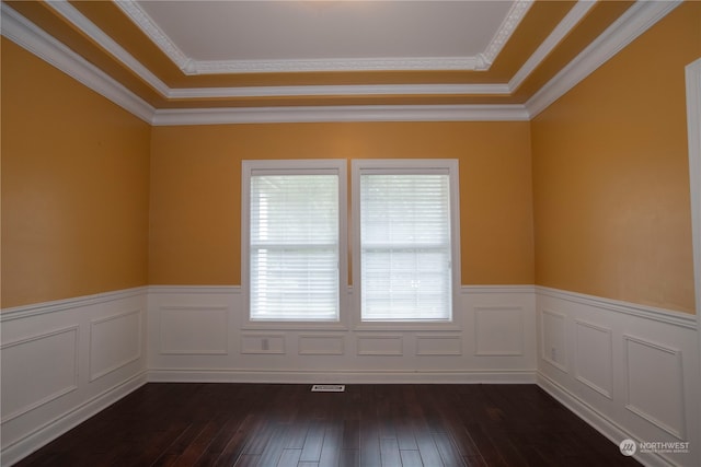 spare room featuring dark hardwood / wood-style floors, ornamental molding, and a tray ceiling