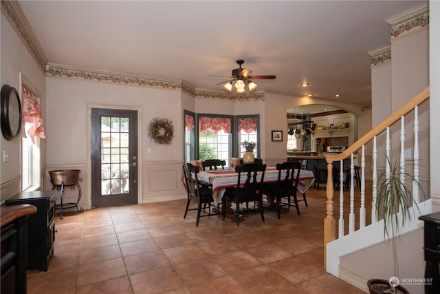 dining area featuring ceiling fan, ornamental molding, and light tile floors