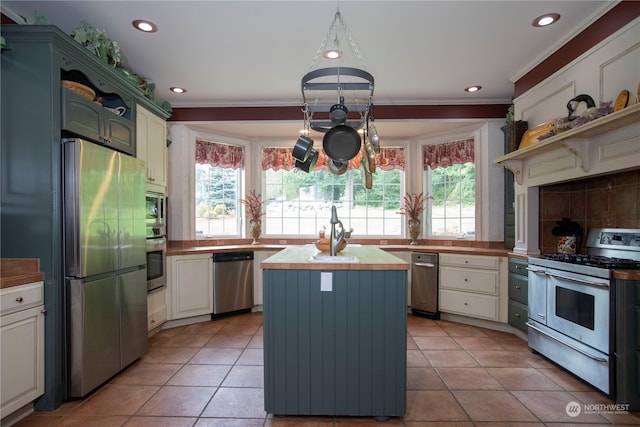 kitchen with wooden counters, appliances with stainless steel finishes, light tile floors, and plenty of natural light