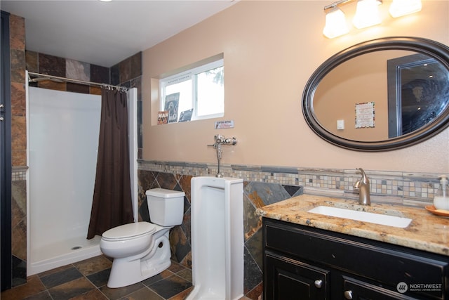 bathroom featuring tile walls, tile floors, toilet, vanity with extensive cabinet space, and curtained shower