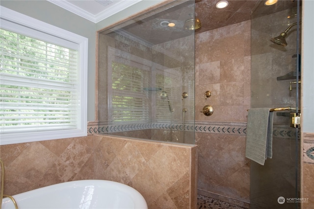 bathroom featuring shower with separate bathtub, tile walls, a healthy amount of sunlight, and ornamental molding