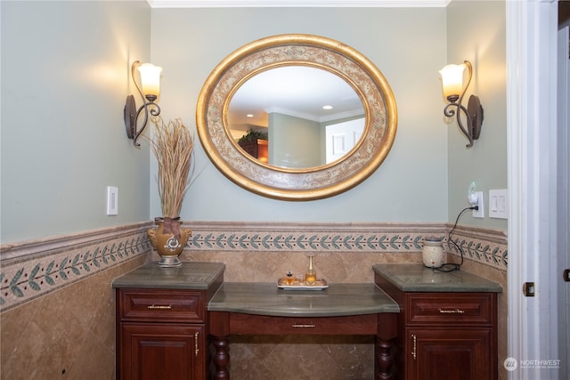 bathroom featuring tile walls, ornamental molding, and vanity