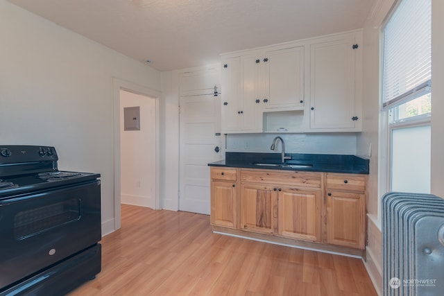 kitchen featuring white cabinets, light hardwood / wood-style floors, electric range, and sink