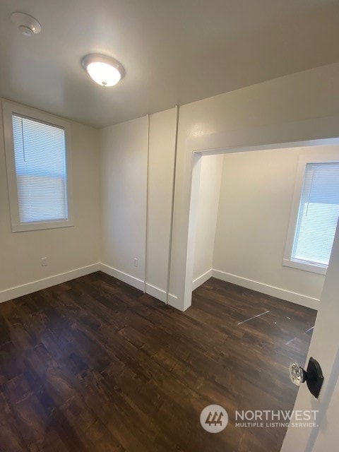 unfurnished room featuring dark wood-type flooring