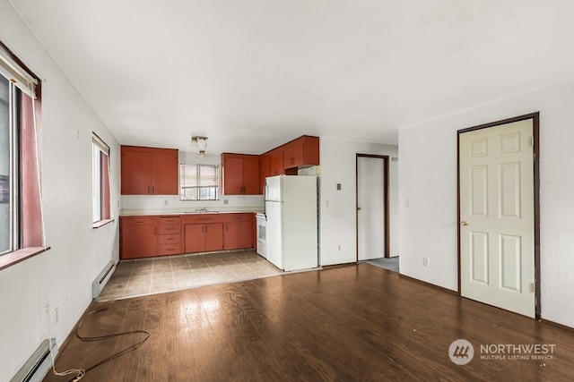 kitchen with baseboard heating, white appliances, light hardwood / wood-style flooring, and sink