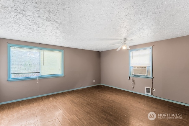 spare room with ceiling fan, a textured ceiling, and wood-type flooring