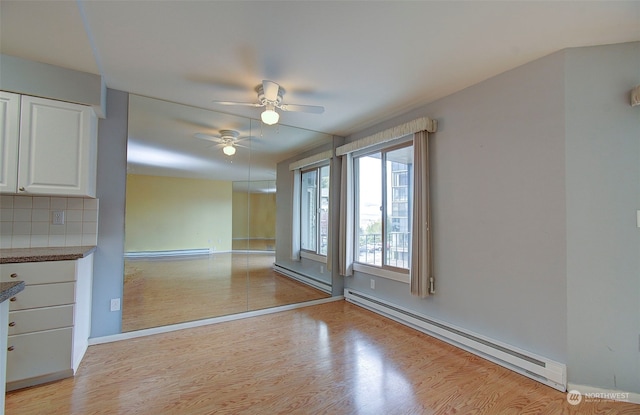 empty room featuring ceiling fan, a baseboard radiator, and light hardwood / wood-style flooring