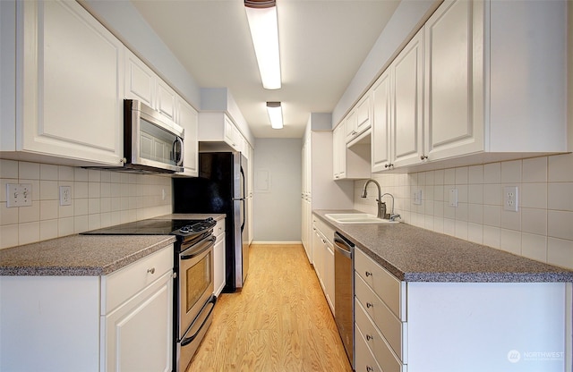 kitchen featuring light hardwood / wood-style flooring, sink, stainless steel appliances, backsplash, and white cabinetry