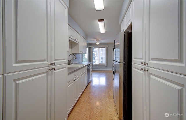 kitchen with ceiling fan, white cabinets, sink, light hardwood / wood-style floors, and appliances with stainless steel finishes