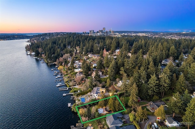 aerial view at dusk featuring a water view