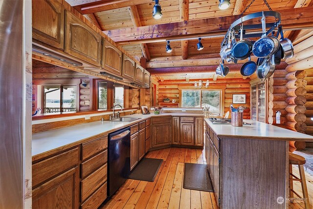 kitchen with dishwasher, sink, a kitchen bar, light hardwood / wood-style floors, and kitchen peninsula