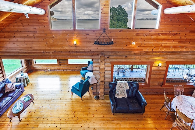 living room featuring hardwood / wood-style flooring, a wall mounted air conditioner, high vaulted ceiling, and beamed ceiling