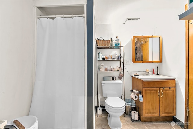 bathroom with vanity, tile floors, and toilet