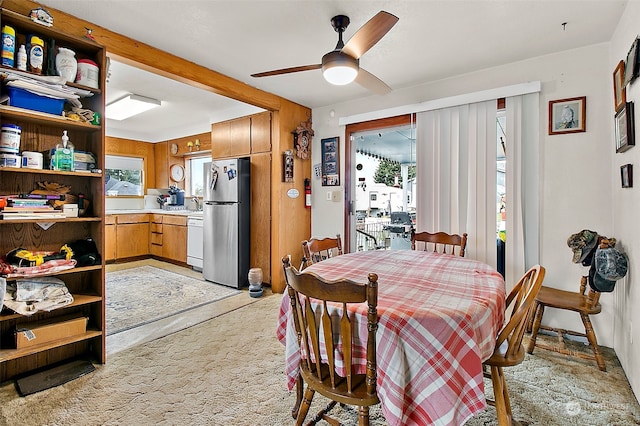 carpeted dining space featuring ceiling fan