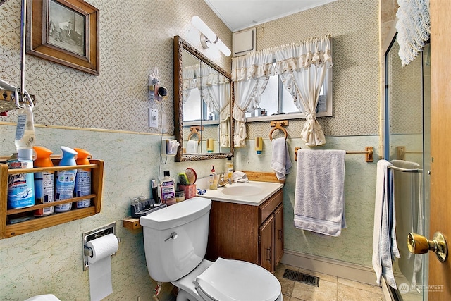 bathroom with a shower with shower door, crown molding, toilet, and large vanity