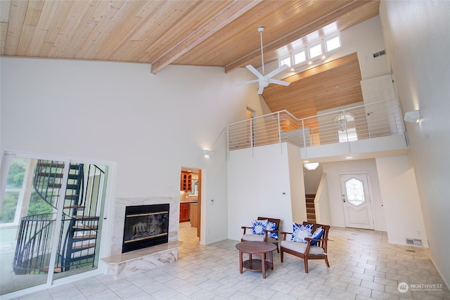 entrance foyer with high vaulted ceiling, light tile patterned floors, wooden ceiling, ceiling fan, and a high end fireplace